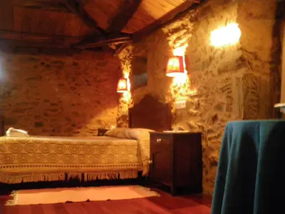 a bedroom with a bed in a stone wall at Casa Torres in Cruces