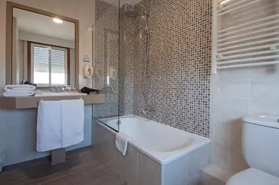 a bathroom with a tub and a toilet and a sink at Hotel & Spa Carlos desde 1996 in Melide