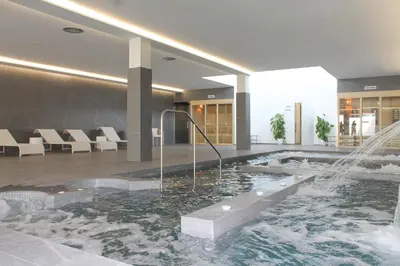 a swimming pool with a fountain in a building at Hotel & Spa Carlos desde 1996 in Melide