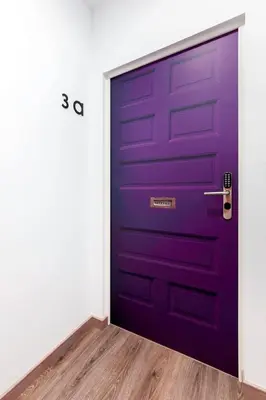 a purple door in a room with a wooden floor at Lux Apartamentos Santiago in Santiago de Compostela