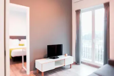 a living room with a tv and a white cabinet at Lux Apartamentos Santiago in Santiago de Compostela