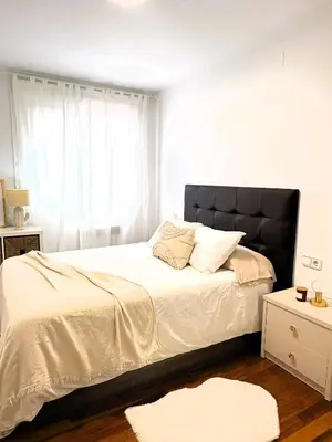 a bedroom with a large bed with a black headboard at EnBURELA Sol y Playa in Burela de Cabo