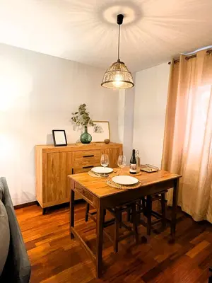 a dining room table with glasses and a chandelier at EnBURELA Sol y Playa in Burela de Cabo