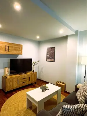 a living room with a couch and a tv at EnBURELA Sol y Playa in Burela de Cabo