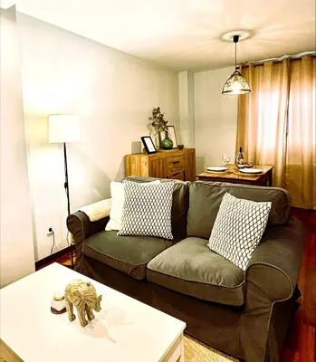 a living room with a couch and a table at EnBURELA Sol y Playa in Burela de Cabo