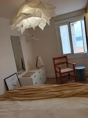 a bedroom with a bed and a mirror and a chair at Casita en Fontán in Sada