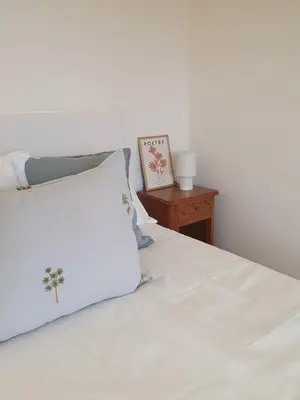 a white bed with a white pillow and a nightstand at Casita en Fontán in Sada