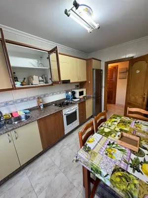 a kitchen with a table and a counter top at Apartamento Arnela Foz in Foz