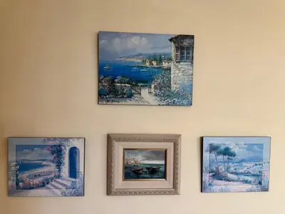four pictures hanging on a wall with paintings at Apartamento Arnela Foz in Foz