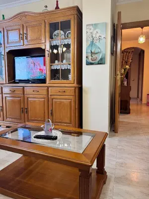 a wooden entertainment center with a tv and a coffee table at Apartamento Arnela Foz in Foz