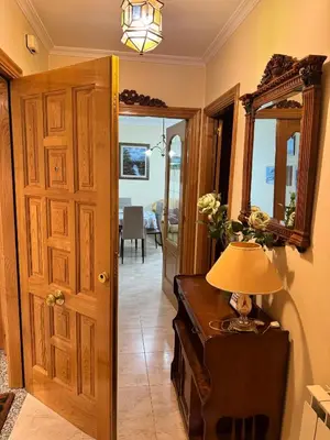 a hallway with a door and a lamp on a table at Apartamento Arnela Foz in Foz