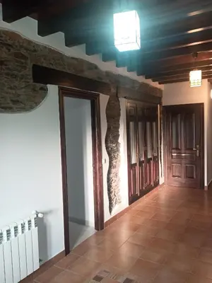 an empty room with wooden ceilings and wooden doors at Casa Peruxo in Ribadeo