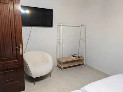 a room with a chair and a television on a wall at Casa Peruxo in Ribadeo