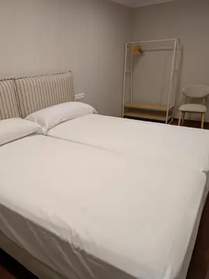 a large white bed in a room with a mirror at Casa Peruxo in Ribadeo
