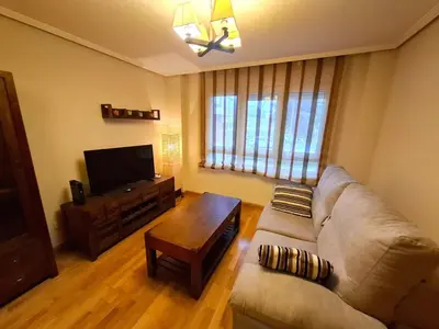 a living room with a couch and a flat screen tv at Apartamento Playa Foz in Foz