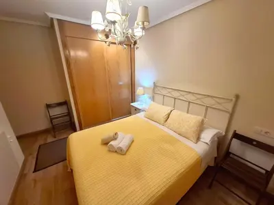 a bedroom with a yellow bed with a yellow blanket at Apartamento Playa Foz in Foz