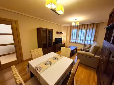 a living room with a table and chairs and a couch at Apartamento Playa Foz in Foz