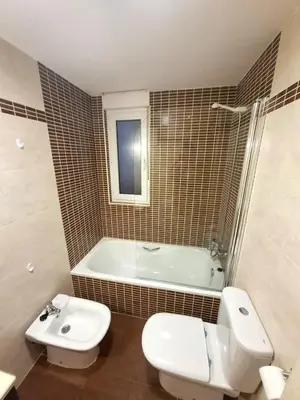 a bathroom with a toilet and a tub and a sink at Apartamento Playa Foz in Foz