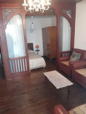 a bedroom with two beds and a couch and a chandelier at casa en casco histórico in Allariz