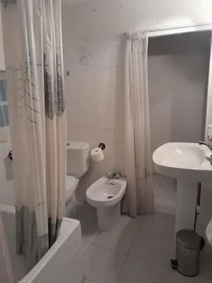 a white bathroom with a toilet and a sink at casa en casco histórico in Allariz