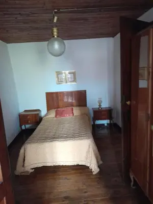 a bedroom with a large bed with a wooden headboard at casa en casco histórico in Allariz