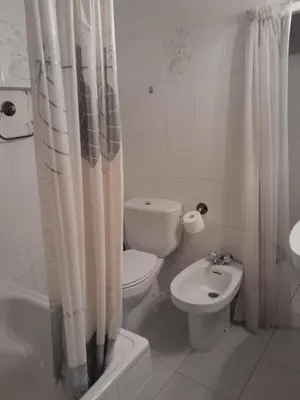 a white bathroom with a toilet and a sink at casa en casco histórico in Allariz