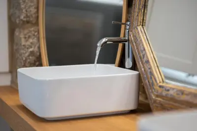 a white sink with a water faucet next to a mirror at Granxa D Outeiro in Ribadavia