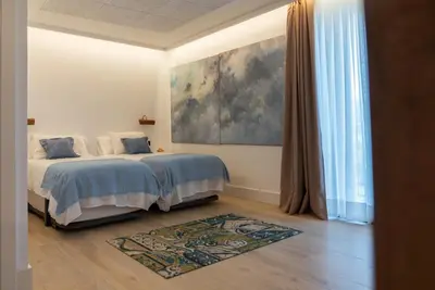 a bedroom with a bed and a painting on the wall at Granxa D Outeiro in Ribadavia