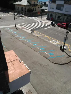 an empty street with blue writing on the road at Hotel Puente de los Santos in Tapia de Casariego