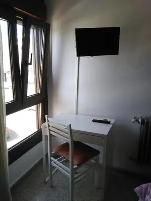 a white desk with a chair next to a window at Hotel Puente de los Santos in Tapia de Casariego