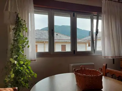 a table with a basket on it in a room with windows at Alojamiento Sena VUT LE-1254 in Villablino