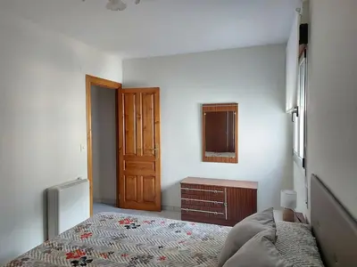 a bedroom with a bed and a wooden door at Alojamiento Sena VUT LE-1254 in Villablino