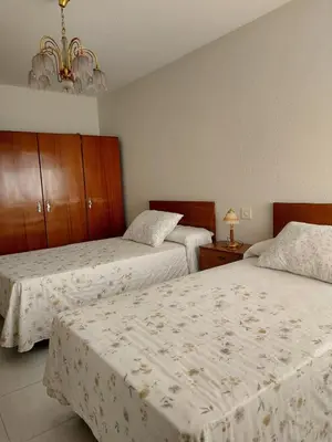 a bedroom with two beds and a chandelier at Alojamiento Sena VUT LE-1254 in Villablino