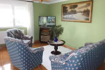 a living room with two chairs and a table and a television at casa jeronimo in Taramundi