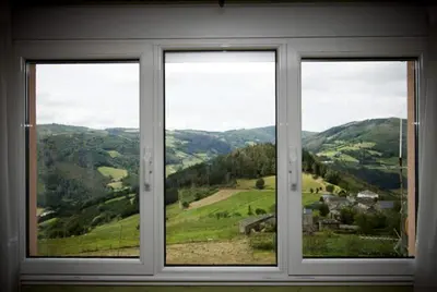 a window with a view of a green valley at casa jeronimo in Taramundi