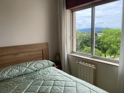 a bedroom with a bed and a window at Piso Brisa de Barreiros in San Cosme de Barreiros