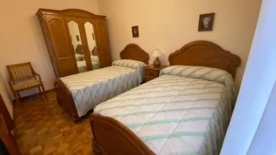 a bedroom with two beds and a mirror at Piso Brisa de Barreiros in San Cosme de Barreiros