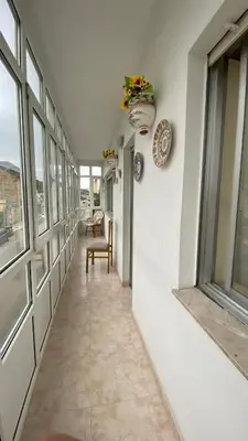 a hallway with windows and a table and a chair at Piso Brisa de Barreiros in San Cosme de Barreiros
