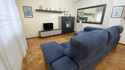 a living room with a blue couch and a television at Piso Brisa de Barreiros in San Cosme de Barreiros