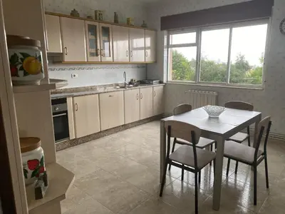 a kitchen with a table and chairs and a table and a kitchen with a window at Piso Brisa de Barreiros in San Cosme de Barreiros