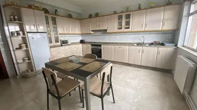 a kitchen with a table and chairs and a refrigerator at Piso Brisa de Barreiros in San Cosme de Barreiros