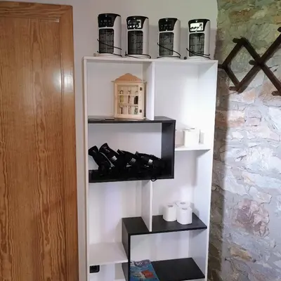 a shelf with wine bottles and cups in a room at casa rural San Vicente Borrenes in Borrenes