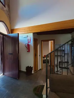 a hallway with a door and a fire extinguisher on the wall at casa rural San Vicente Borrenes in Borrenes