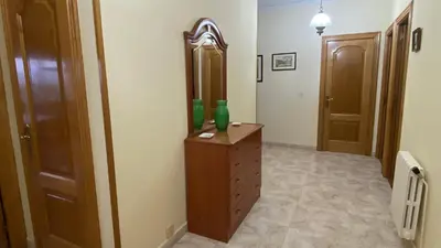 a hallway with a wooden dresser and a mirror at Piso Mirador de San Cosme in San Cosme de Barreiros