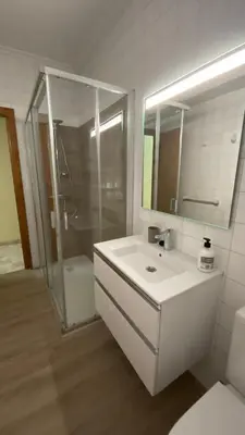 a bathroom with a sink and a shower and a mirror at Piso Mirador de San Cosme in San Cosme de Barreiros