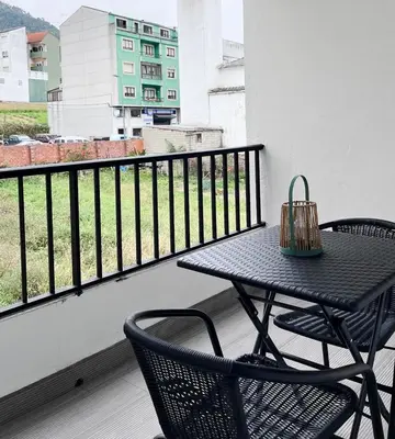 a black table and chairs on a balcony with a view at Eneas I , II in A Pontenova