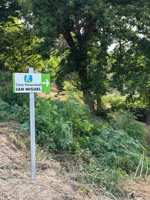 a sign in the grass next to a tree at Casa vacacional San Miguel in Maside