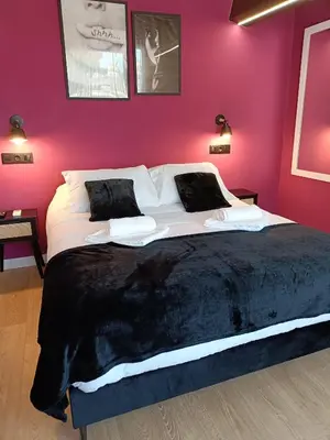 a large bed in a bedroom with a pink wall at Casa vacacional San Miguel in Maside