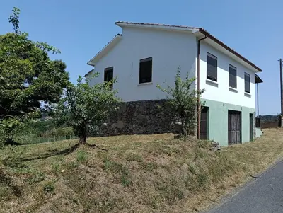a white house on a hill with a tree at Casa Quinzan Ribeira Sacra in Taboada