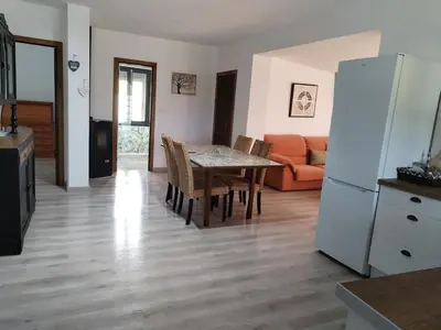 a kitchen and living room with a table and a refrigerator at Casa Quinzan Ribeira Sacra in Taboada